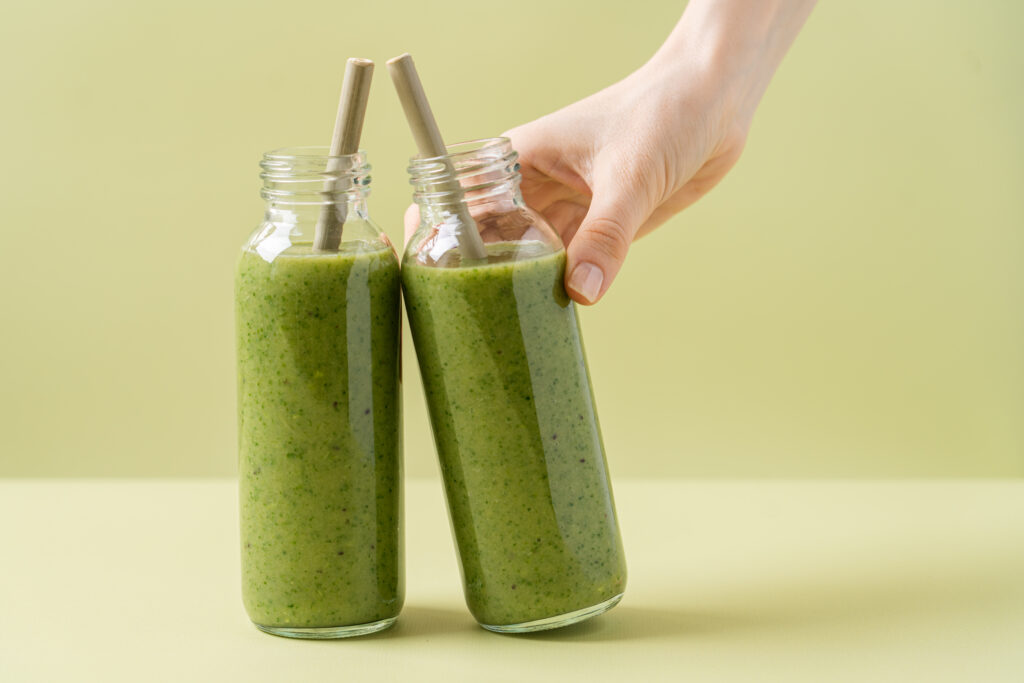 Green Smoothie In Glass Bottles With Bamboo Tubes