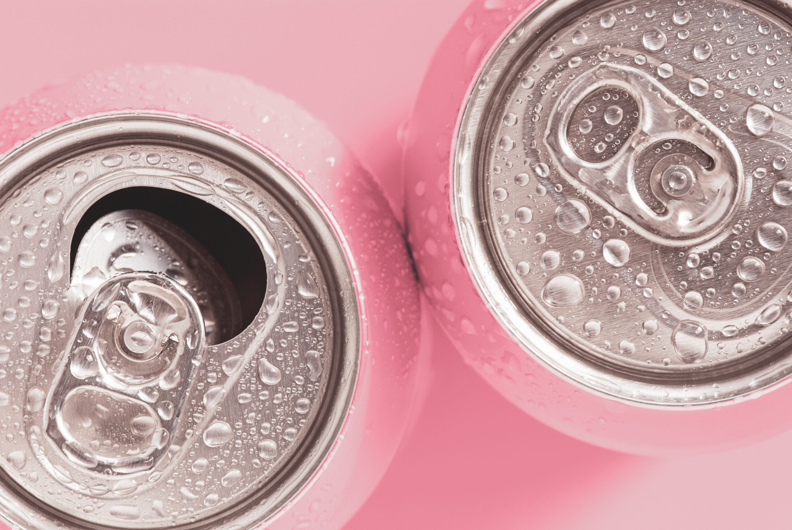Pink Soda Cans In Water Drops, Top View