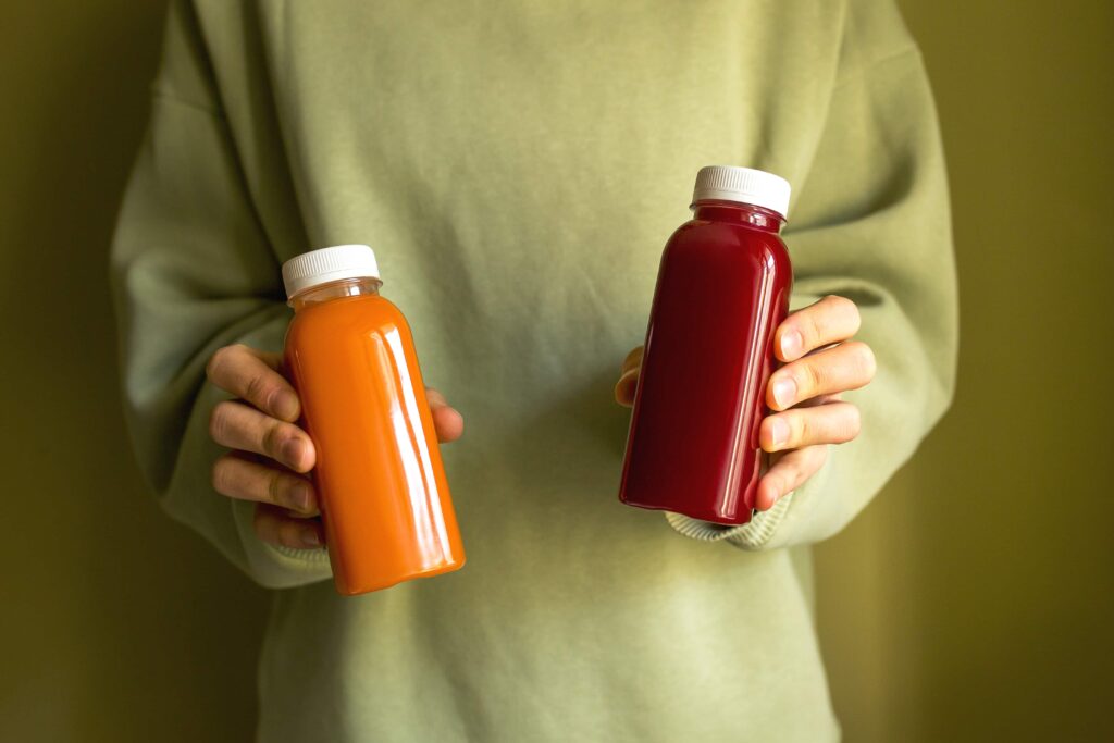 person holding juice bottles